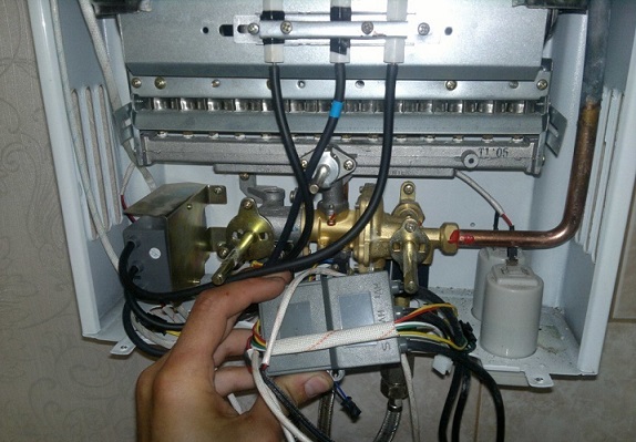 Мастер ремонтирует газовую колонку